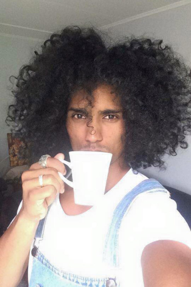 Hombre negro guapo bebiendo café o té.