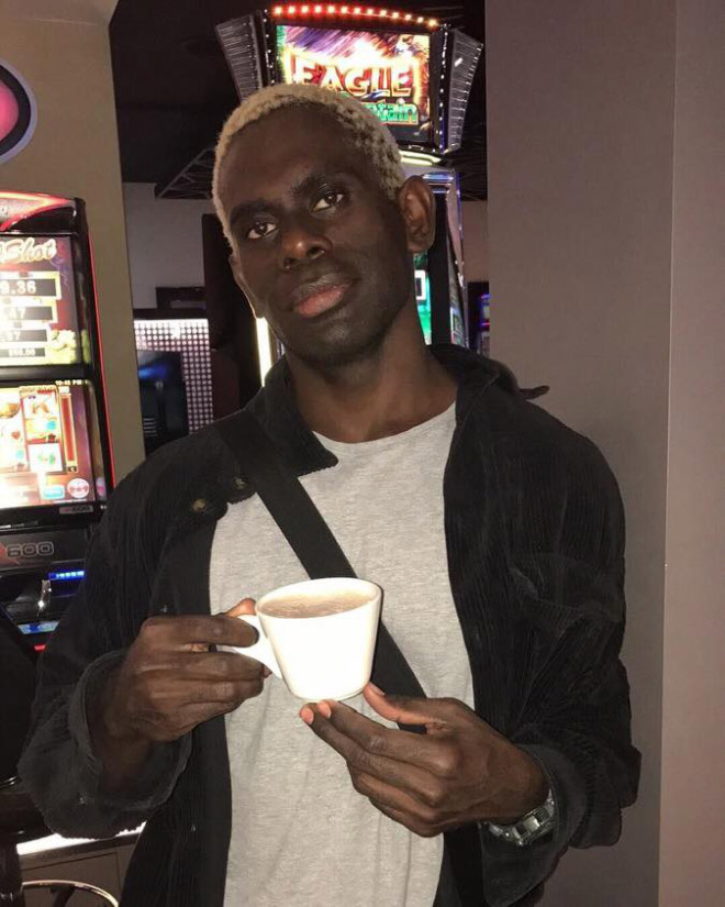 Hombre negro guapo bebiendo café o té.